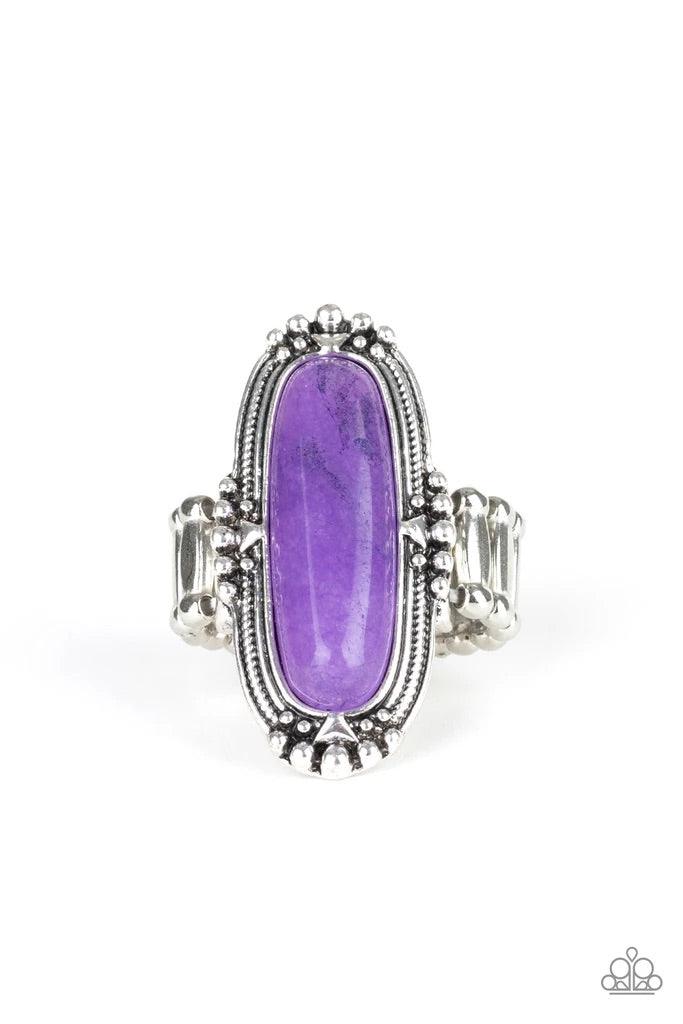 Paparazzi Accessories Desert Tranquility - Purple Featuring an oblong shape, a glassy purple stone bead is pressed into a studded silver frame atop the finger for a seasonal flair. Features a stretchy band for a flexible fit. Sold as one individual ring.