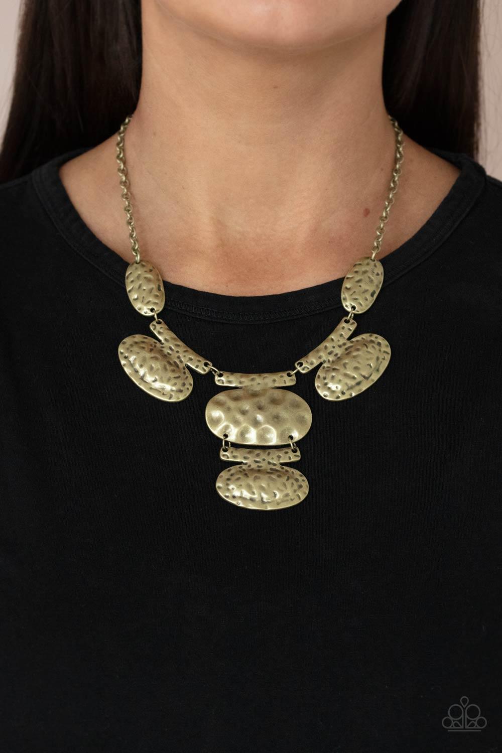Paparazzi Accessories Gallery Relic - Brass Attached to bar-like plates, mismatched brass oval plates link below the collar, creating an intense industrial statement below the collar. Features an adjustable clasp closure. Sold as one individual necklace.