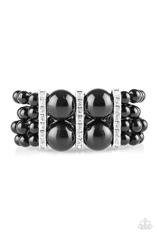 Paparazzi Accessories Romance Remix - Black Strands of shiny black beads are threaded along stretchy elastic bands and joined together by white rhinestone encrusted frames. The glittery frames combine with oversized beads at the center, adding a dramatic