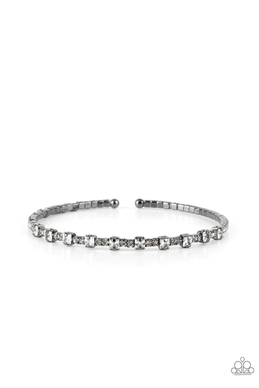 Paparazzi Accessories Timelessly Tiny - Black Featuring sleek gunmetal fittings, a classic band of dainty white rhinestones is interrupted with square cut white rhinestones, adding a timeless twist to the stackable cuff. Sold as one individual bracelet. B