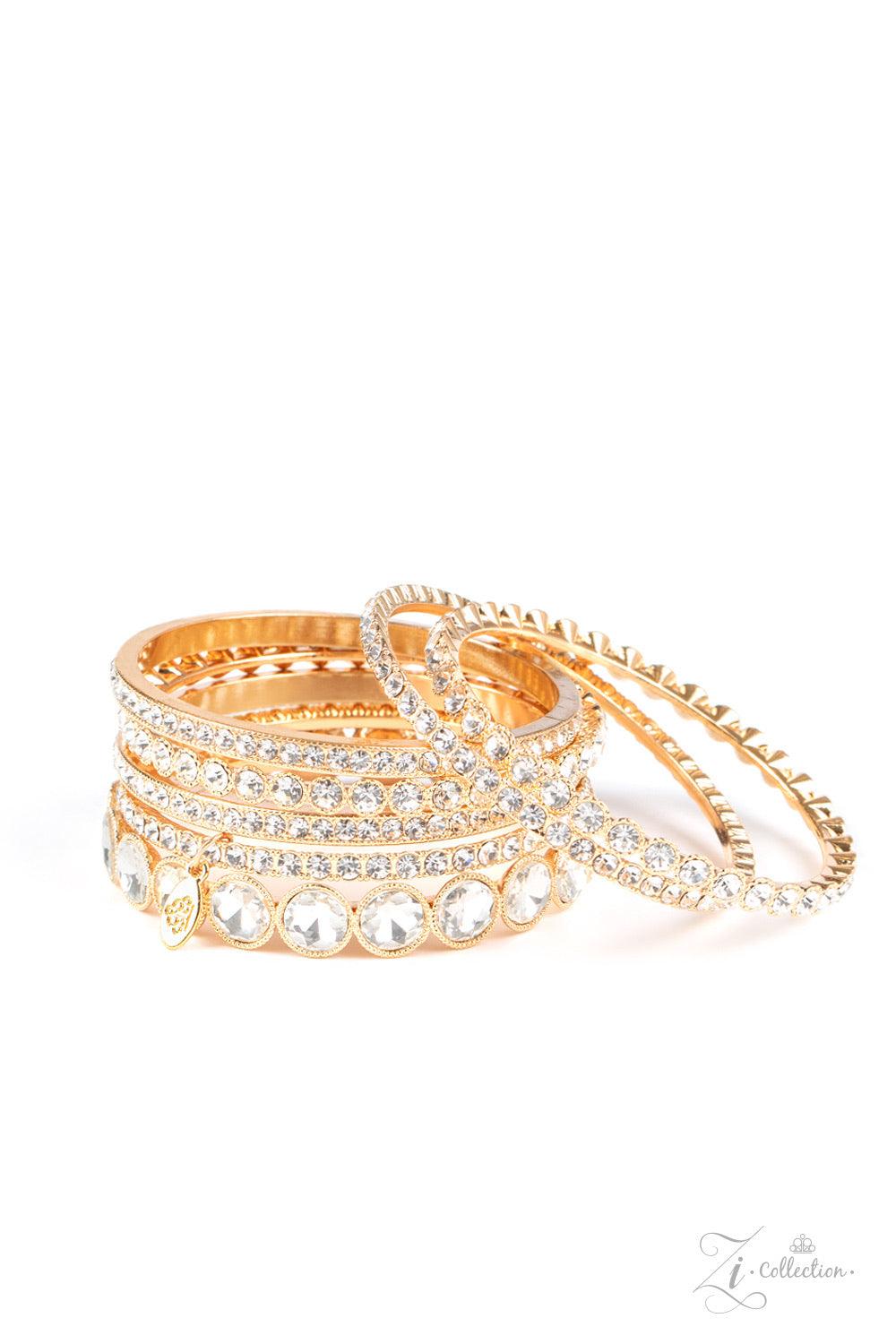 Paparazzi Accessories Future Fashionista An oversized collection of glittery white rhinestones are encrusted across the front of elegantly mismatched gold bangles. The blinding collection stacks and slides across the wrist, creating spellbinding sparkle w