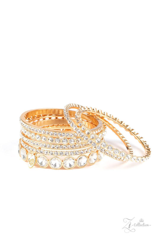 Paparazzi Accessories Future Fashionista An oversized collection of glittery white rhinestones are encrusted across the front of elegantly mismatched gold bangles. The blinding collection stacks and slides across the wrist, creating spellbinding sparkle w