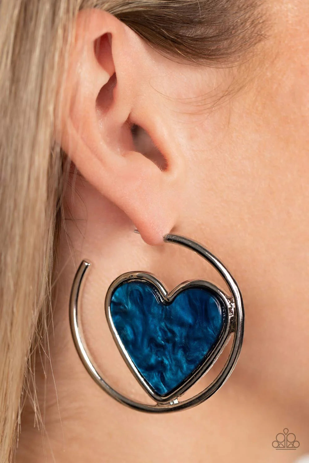 Paparazzi Accessories Smitten With You - Blue Featuring a faux marble finish, a glistening blue heart nestles inside of an asymmetrical silver hoop for a flirtatious pop of color. Earring attaches to a standard post fitting. Hoop measures approximately 2"