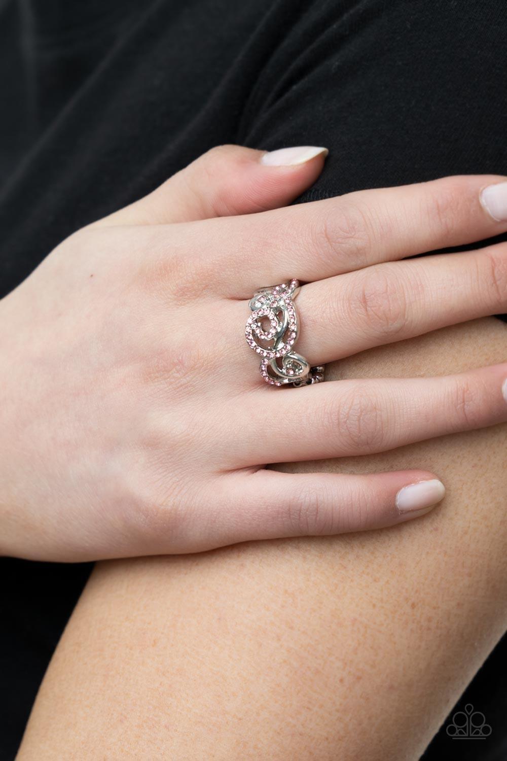 Paparazzi Accessories Melodic Motion - Pink An ornamental silver scrollwork frame, adorned with dainty sparkling pink rhinestones travels across the finger in a melodic display. Features a dainty stretchy band for a flexible fit. Jewelry