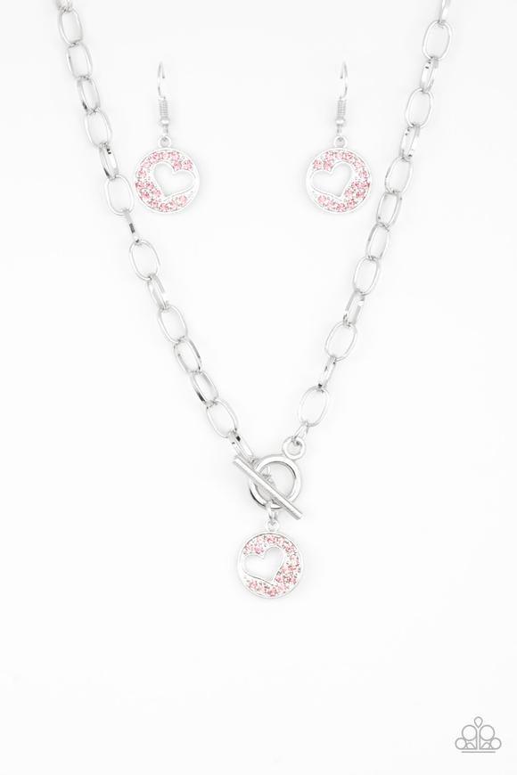 Paparazzi Accessories Heartbeat Retreat - Pink Radiating with glittery pink rhinestones, an airy heart pendant swings from the bottom of a glistening silver chain below the collar for a flirty flair. Features a toggle clasp. Sold as one individual necklac