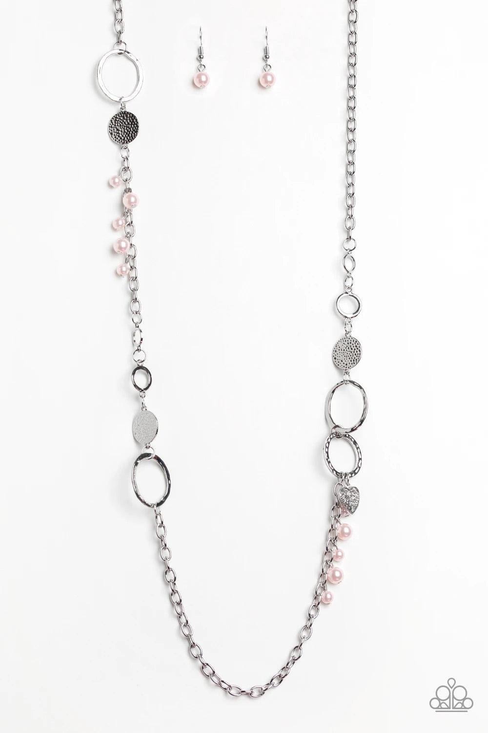 Paparazzi Accessories Unapologetic Flirt - Pink Infused with sections of shimmery silver chains, an assortment of hammered silver discs and silver rings link across the chest. A collection of pearly pink beads and dainty silver heart charms asymmetrically