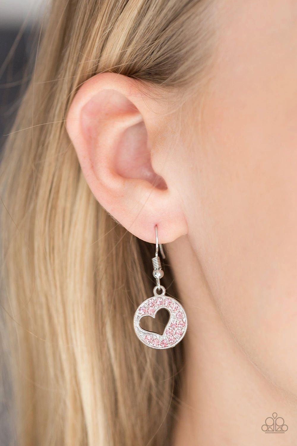 Paparazzi Accessories Heartbeat Retreat - Pink Radiating with glittery pink rhinestones, an airy heart pendant swings from the bottom of a glistening silver chain below the collar for a flirty flair. Features a toggle clasp. Sold as one individual necklac