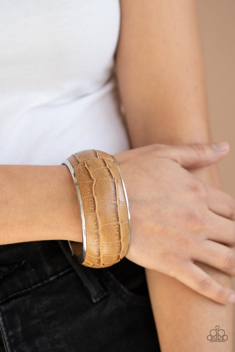 Paparazzi Accessories Urban Jungle - Brown Featuring a subtle crocodile print, a faux piece of tan leather wraps around a dramatically oversized silver bangle for a bold look. Jewelry