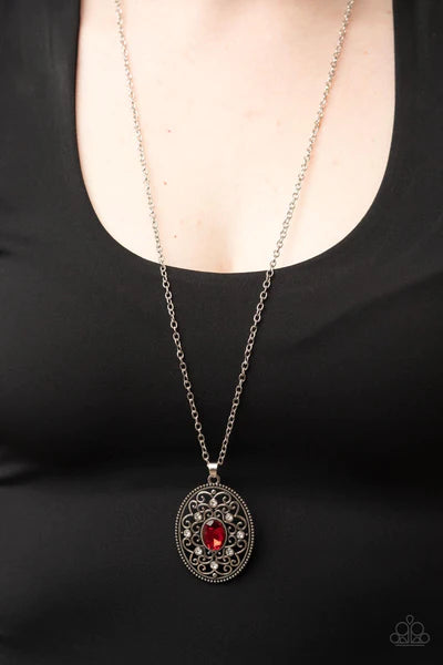 Paparazzi Accessories Sonata Swing - Red Dainty white rhinestones are sprinkled across silver vine-like filigree that whirls around an oval red gem center inside of a studded silver frame, resulting in a whimsical pendant at the bottom of a silver chain.