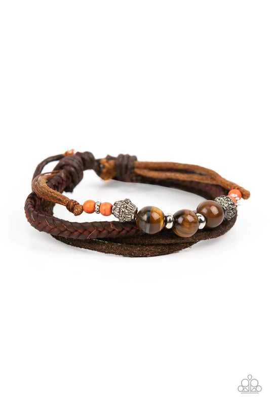 Paparazzi Accessories Tundra Tracker - Orange A strand of tiger's eye stones, orange accents, and decorative silver beads join layers of mismatched leather bands around the wrist for a groovy grounding effect. Features an adjustable sliding knot closure.