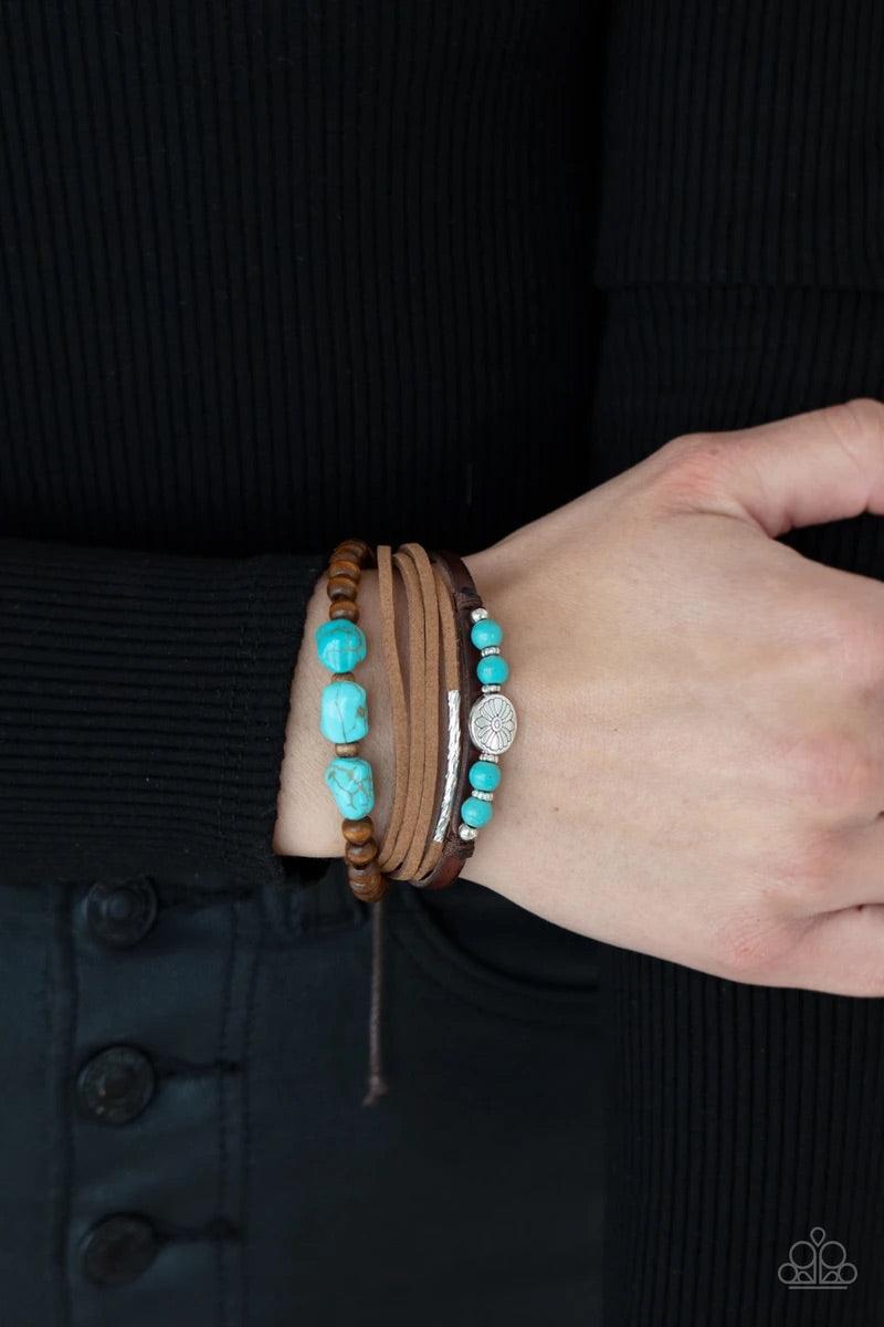 Paparazzi Accessories Act Natural - Blue Featuring natural turquoise stones and silver accents, a collection of leather strands and wooden beads encircle the wrist in a subtle Southwestern fashion. Features an adjustable sliding knot closure. Sold as one