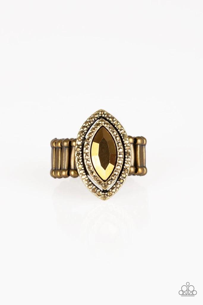 Paparazzi Accessories Modern Millionaire - Brass Featuring a regal marquise style cut, a golden aurum gem is pressed into the center of stacked brass frames radiating with glittery aurum rhinestones for a glamorous finish. Features a stretchy band for a f