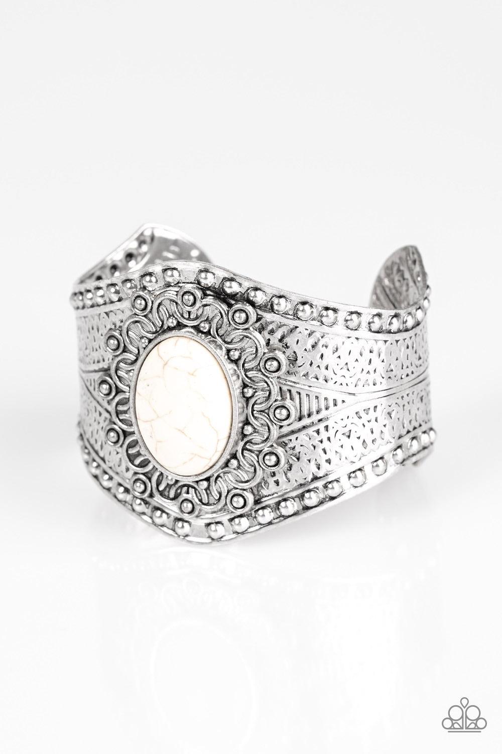 Paparazzi Accessories Majave Majesty - White Delicately hammered and studded in tribal inspired textures, a thick silver cuff wraps around the wrist in an artisan inspired fashion. A smooth white stone is pressed into the middle of a silver sunburst patte