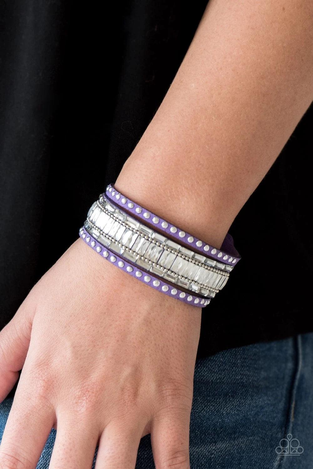 Paparazzi Accessories Rock Star Rocker - Purple Shiny silver studs, dainty silver ball chains, and edgy white emerald-cut rhinestones race along a spliced purple suede band for a rock star look. Features an adjustable snap closure. Sold as one individual