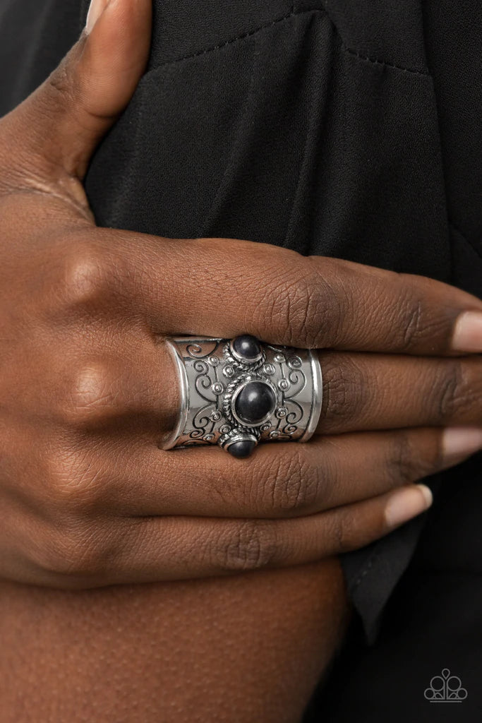 Paparazzi Accessories Southwestern Scenery - Black Dotted with an earthy row of black stones, a rectangular silver frame stamped in tribal inspired patterns folds around the finger for a simply seasonal look. Features a stretchy band for a flexible fit. S