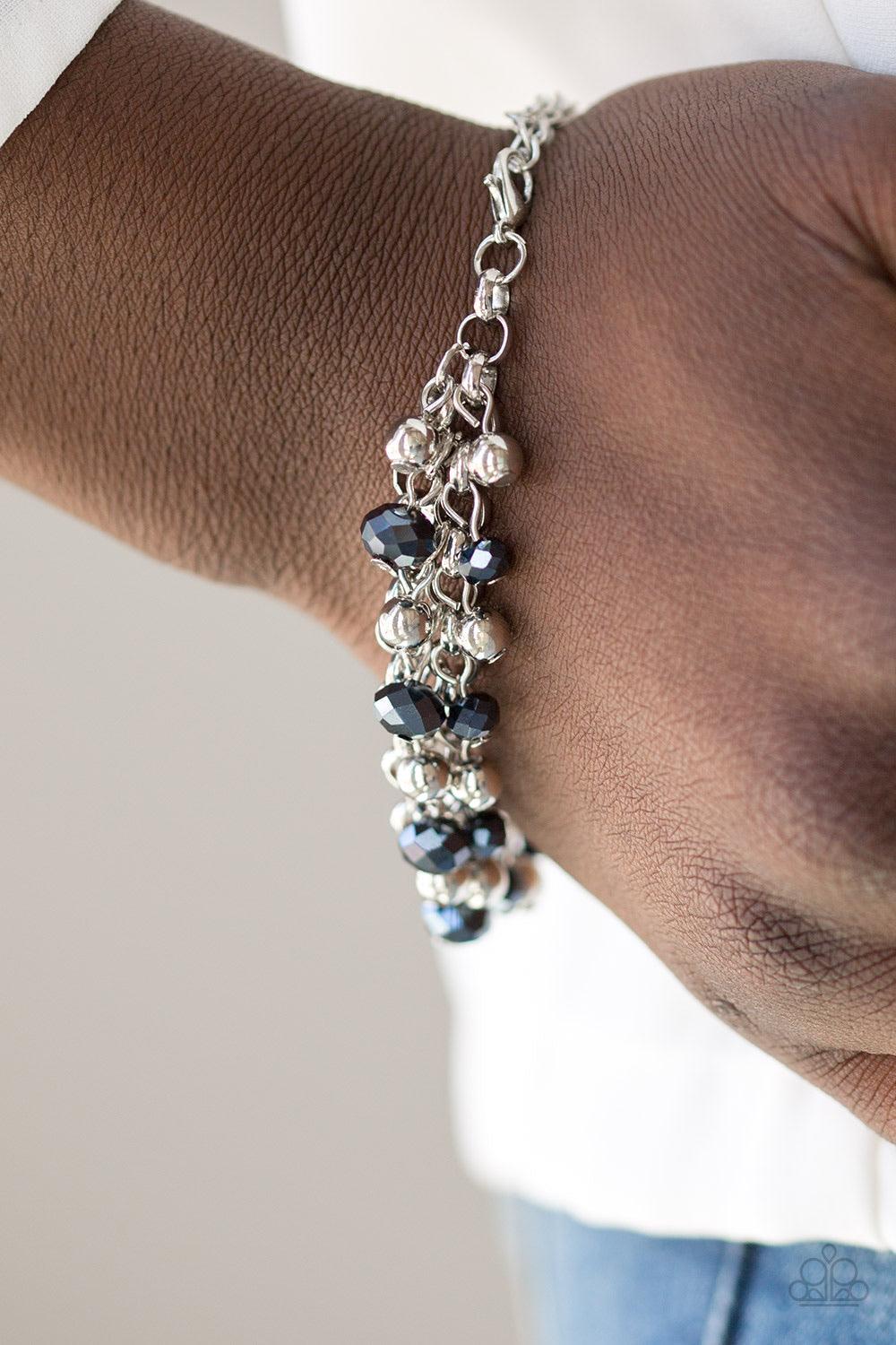 Paparazzi Accessories Just For The FUND Of It! - Blue Dipped in a metallic shimmer, faceted blue beads and classic silver beads swing from interlocking silver chains, creating a refined fringe around the wrist. Features an adjustable clasp closure. Sold a