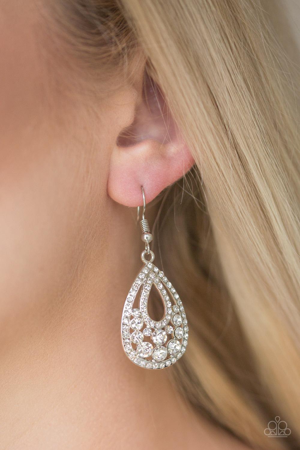 Paparazzi Accessories Sparkling Stardom - White Encrusted in glassy white rhinestones, shimmery silver bars swoop into a glittery teardrop frame. Sparkling white rhinestones are sprinkled across the airy frame for a refined finish. Earring attaches to a s