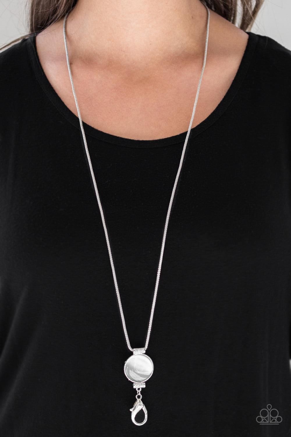Paparazzi Accessories Happy As Can BEAM - White *Lanyard Infused with white rhinestone encrusted fittings, a glowing white moonstone pendant swings from the bottom of a rounded silver mesh chain for a whimsical look. A lobster clasp hangs from the bottom