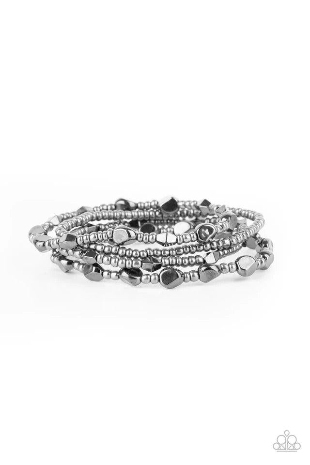Paparazzi Accessories Fashionably Faceted - Black A shimmery collection of dainty gunmetal seed beads and faceted gunmetal accents are threaded along stretchy bands around the wrist, creating glistening layers. Jewelry