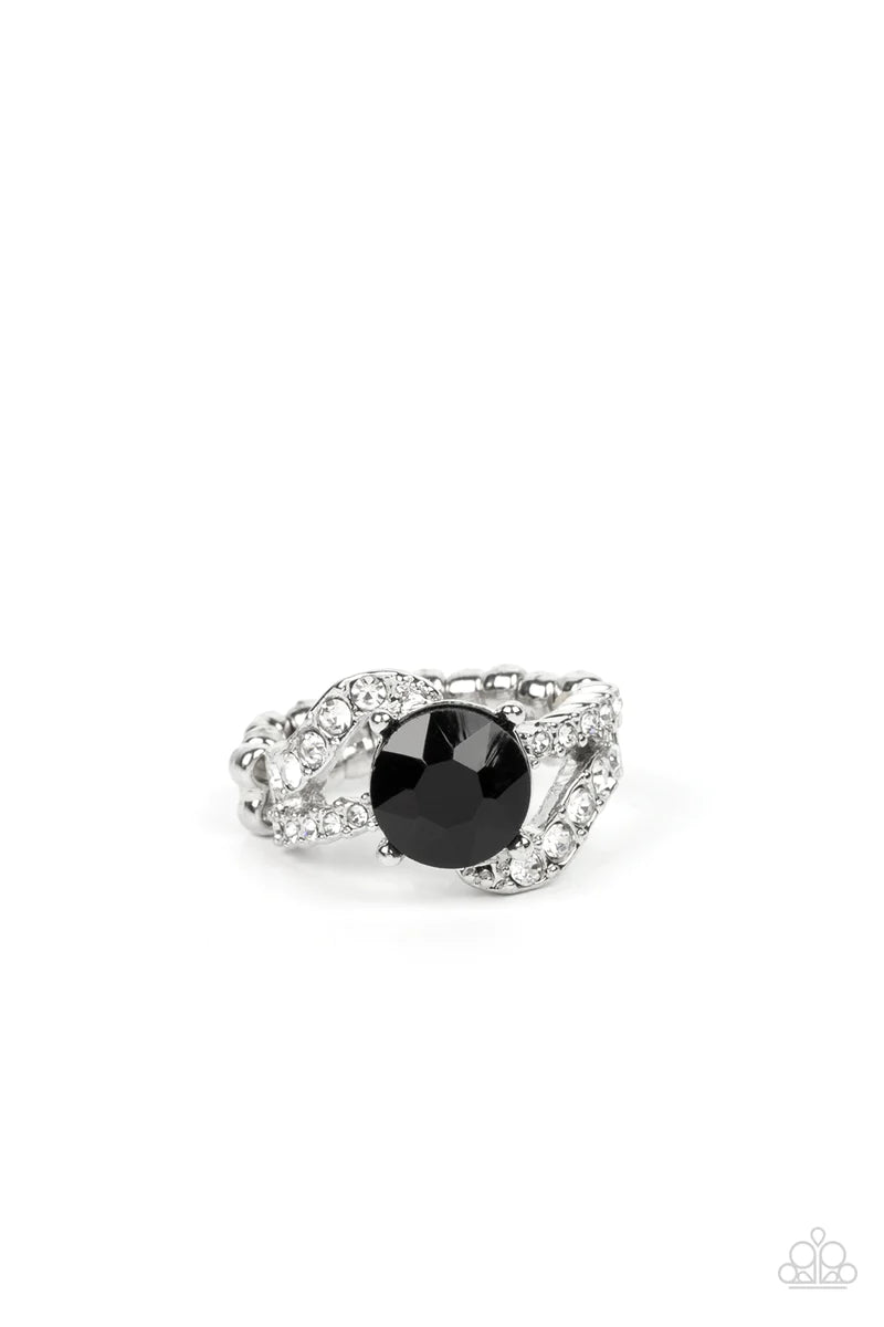 Paparazzi Accessories Blockbuster Boom - Black A faceted black rhinestone in a silver-prong setting makes a glamorously edgy centerpiece as it floats over the top of two silver bands. Encrusted with dainty white rhinestones, the wavy silver bands add dept