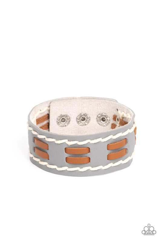 Paparazzi Accessories In the FRONTIER Running - Silver Flanked with two stitched rows, two rows of brown leather laces are threaded through the center of a gray leather band for a rustic pop of color around the wrist. Features an adjustable snap closure.