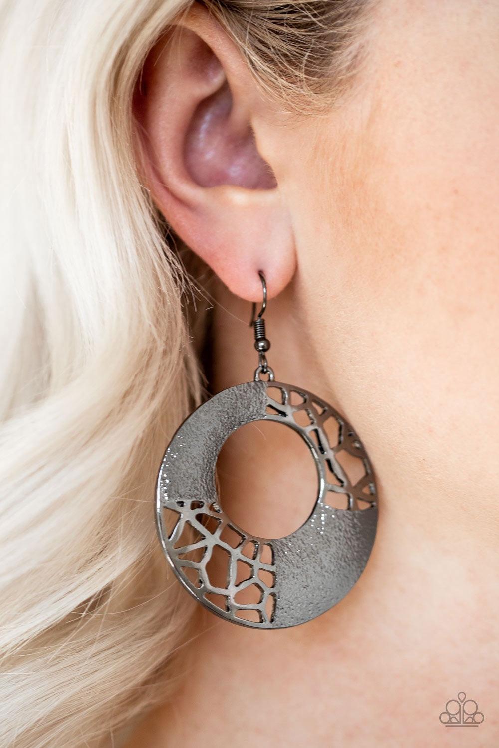 Paparazzi Accessories Shattered Shimmer - Black Featuring sections of shattered metallic patterns, a thick gunmetal hoop swings from the ear in an edgy industrial fashion. Earring attaches to a standard fishhook fitting. Jewelry