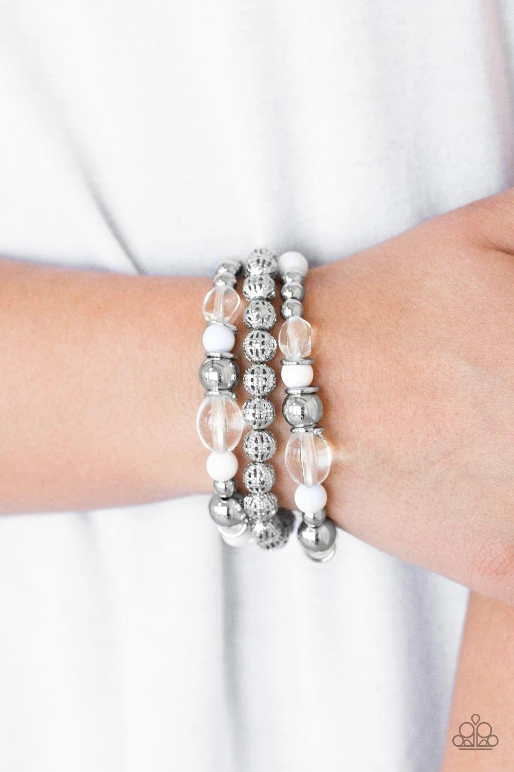 Paparazzi Accessories Malibu Marina - White An array of glassy and polished white beading and mismatched silver accents are threaded along stretchy elastic bands, creating colorful layers across the wrist. Sold as one set of three bracelets. Jewelry