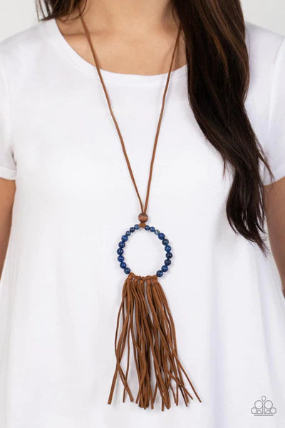 Paparazzi Accessories Namaste Mama - Blue A collection of refreshing lapis lazuli stone beads are threaded around a wire hoop that is fastened at the end of a lengthened brown suede cord. The earthy stones make way for a foxy fringe of brown suede that sw