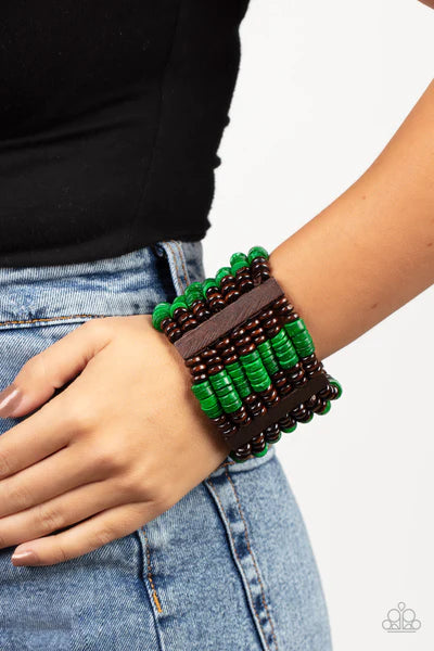 Paparazzi Accessories Vacay Vogue - Green Held together by rectangular wooden frames, rows of brown wooden and distressed Leprechaun discs are threaded along stretchy bands around the wrist for a seasonal pop of color around the wrist. Sold as one individ