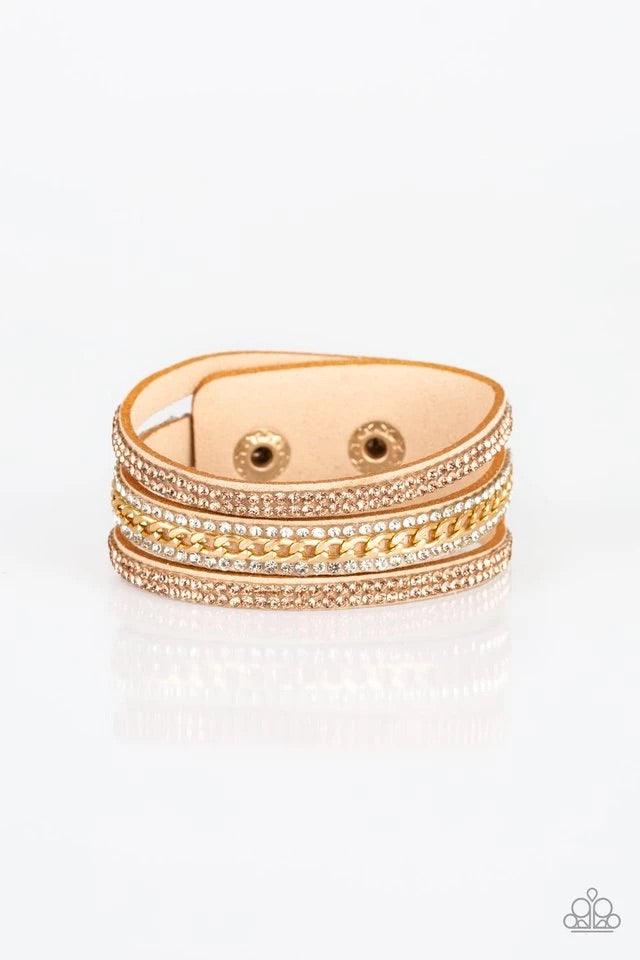 Paparazzi Accessories Rollin In Rhinestones - Gold Rows of glassy peach and white rhinestones and a shimmery gold chain are encrusted along tan suede bands for a sassy look. Features an adjustable snap closure. Jewelry