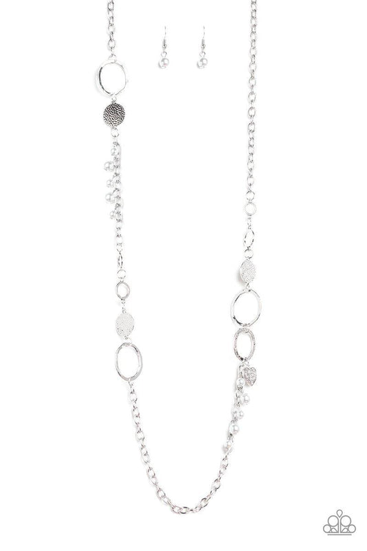 Paparazzi Accessories Unapologetic Flirt - Silver Infused with sections of shimmery silver chains, an assortment of hammered silver discs and silver rings link across the chest. A collection of pearly beads and dainty silver heart charms asymmetrically do