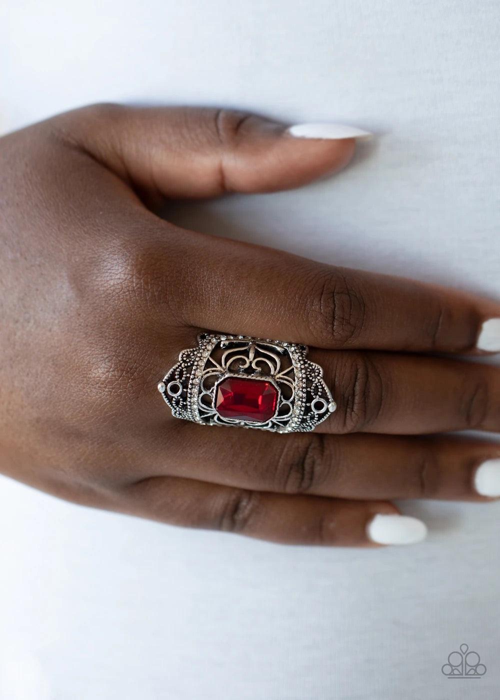 Paparazzi Accessories Undefinable Dazzle - Red Infused with two bands of glittery white rhinestones, smooth and studded silver filigree branches out into a regal backdrop across the finger. Featuring an emerald style cut, a stunning red rhinestone embelli