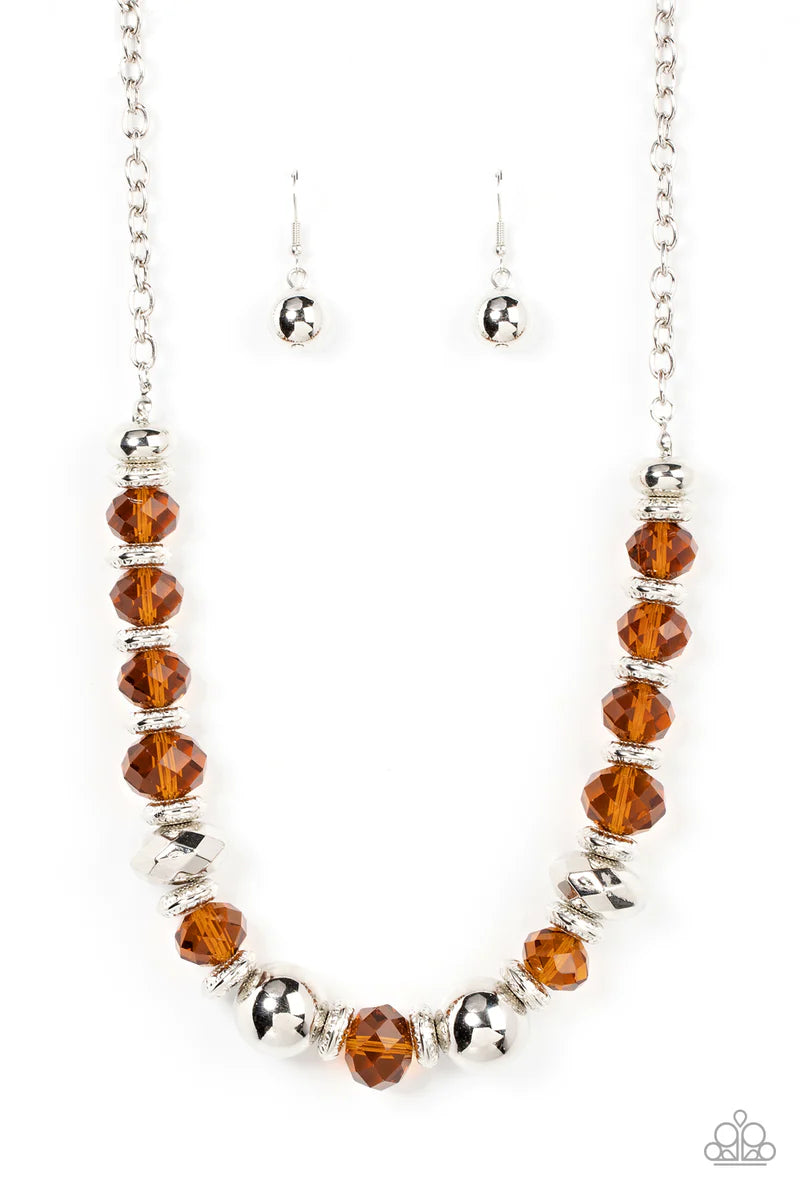 Paparazzi Accessories Interstellar Influencer - Brown A dramatic assortment of oversized silver beads, textured silver rings, and faceted brown crystal-like gems delicately glides along an invisible wire below the collar, resulting in a stellar sparkle. F
