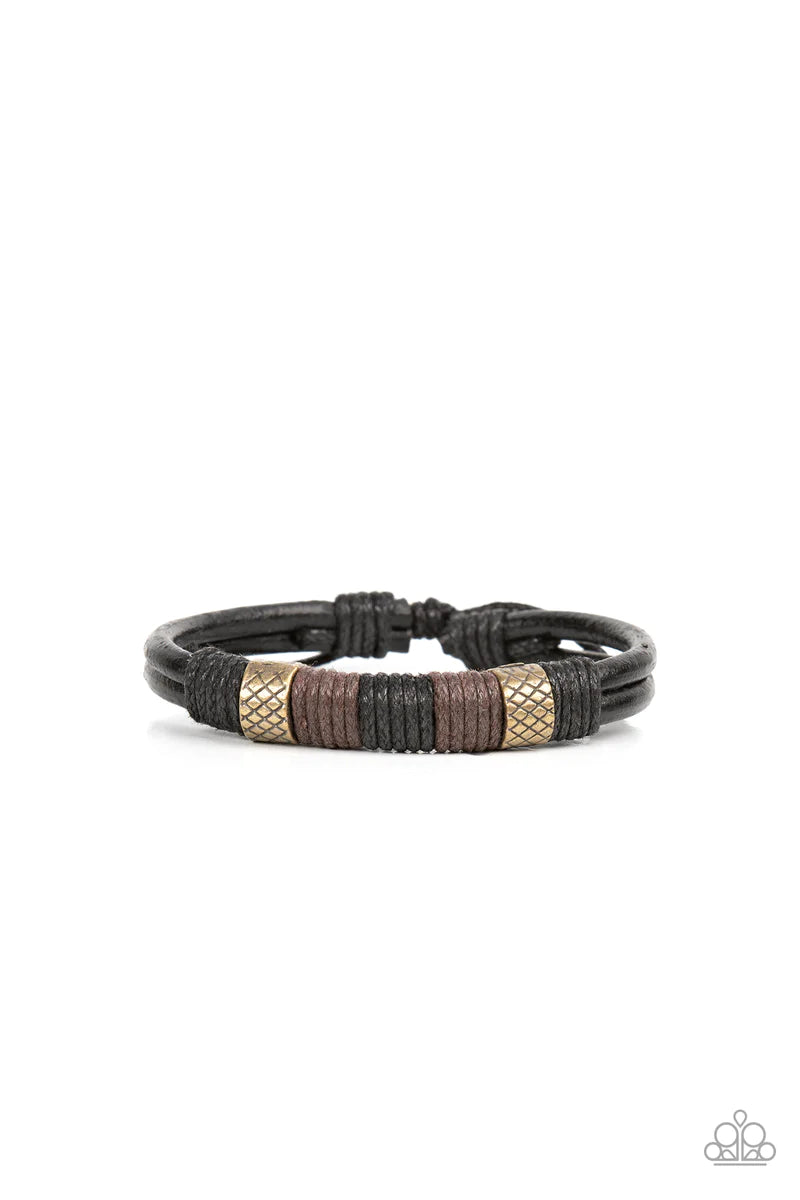 Paparazzi Accessories Forest Dweller - Brass A rustic pair of textured brass beads are knotted in place with black and brown cording around the center of a black leather band, resulting in a rugged centerpiece. Features an adjustable sliding knot closure.
