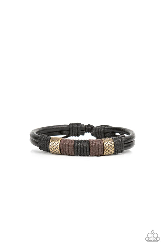 Paparazzi Accessories Forest Dweller - Brass A rustic pair of textured brass beads are knotted in place with black and brown cording around the center of a black leather band, resulting in a rugged centerpiece. Features an adjustable sliding knot closure.