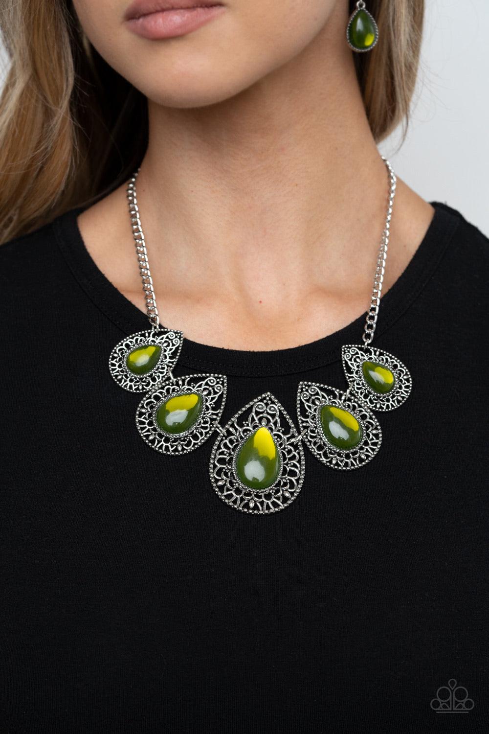 Paparazzi Accessories Opal Auras - Green Featuring an opalescent shimmer, glassy Military Olive teardrop beads are nestled inside shiny silver frames filled with vine-like antiqued filigree. Graduating in size, the whimsical frames delicately link below t