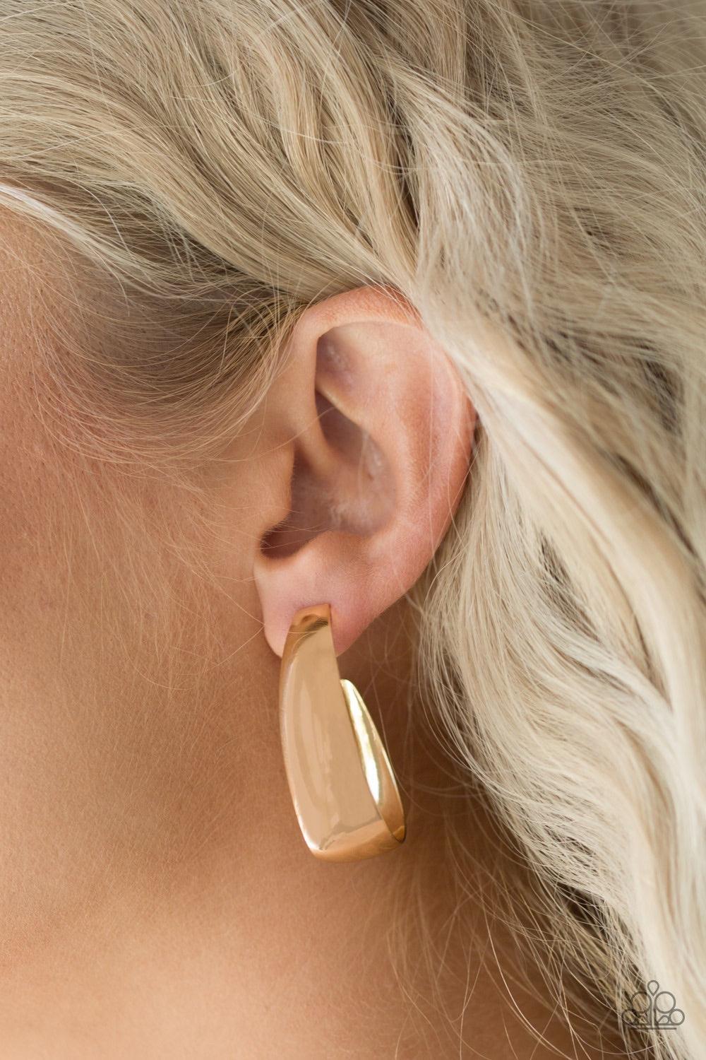 Paparazzi Accessories Gypsy Belle - Gold Brushed in a high-sheen finish, a glistening gold frame sharply curls beneath the ear for a casual look. Earring attaches to a standard post fitting. Hoop measures 1" in diameter. Jewelry