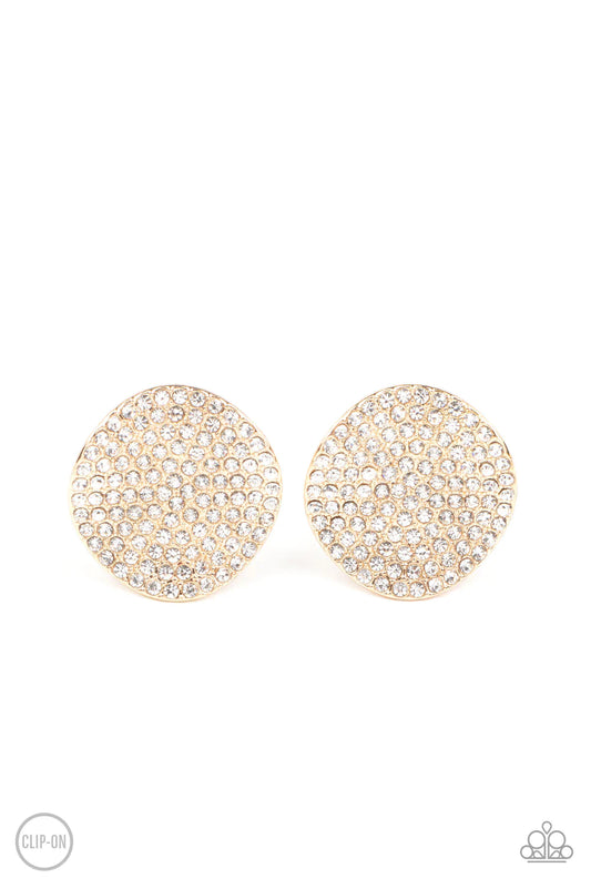 Paparazzi Accessories Lunch at the Louvre *Clip-on The front of a warped gold disc is encrusted in row after row of blinding white rhinestones, resulting in a refined display. Earring attaches to a standard clip-on fitting. Sold as one pair of clip-on ear