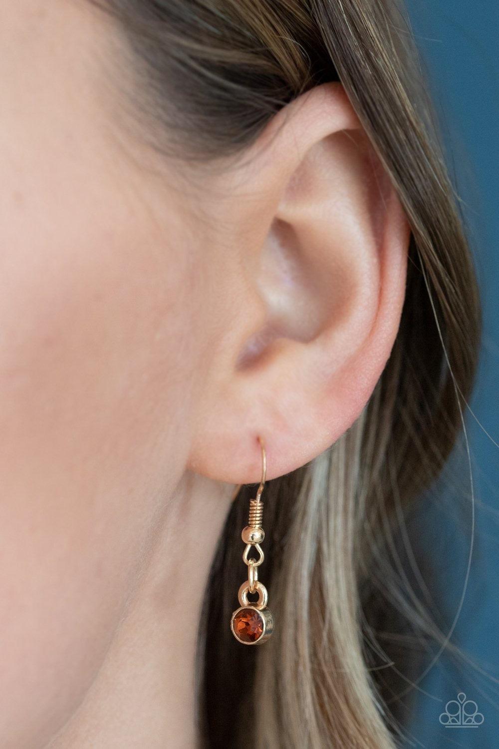 Paparazzi Accessories Top Dollar Twinkle - Brown Pairs of stacked topaz rhinestone frames alternate with solitaire topaz rhinestones crowned in dainty topaz rhinestones along a shiny gold chain, creating a glamorous fringe below the collar. Features an ad