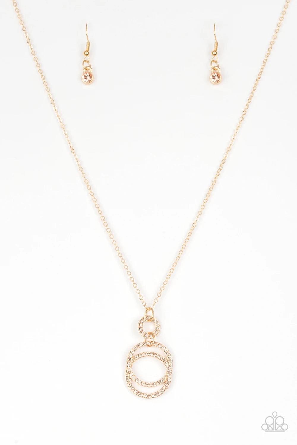 Paparazzi Accessories Timeless Trio - Gold Encrusted in radiant peach rhinestones, three gold hoops interlock at the bottom of an elongated gold chain for an elegant look. Features an adjustable clasp closure. Sold as one individual necklace. Includes one