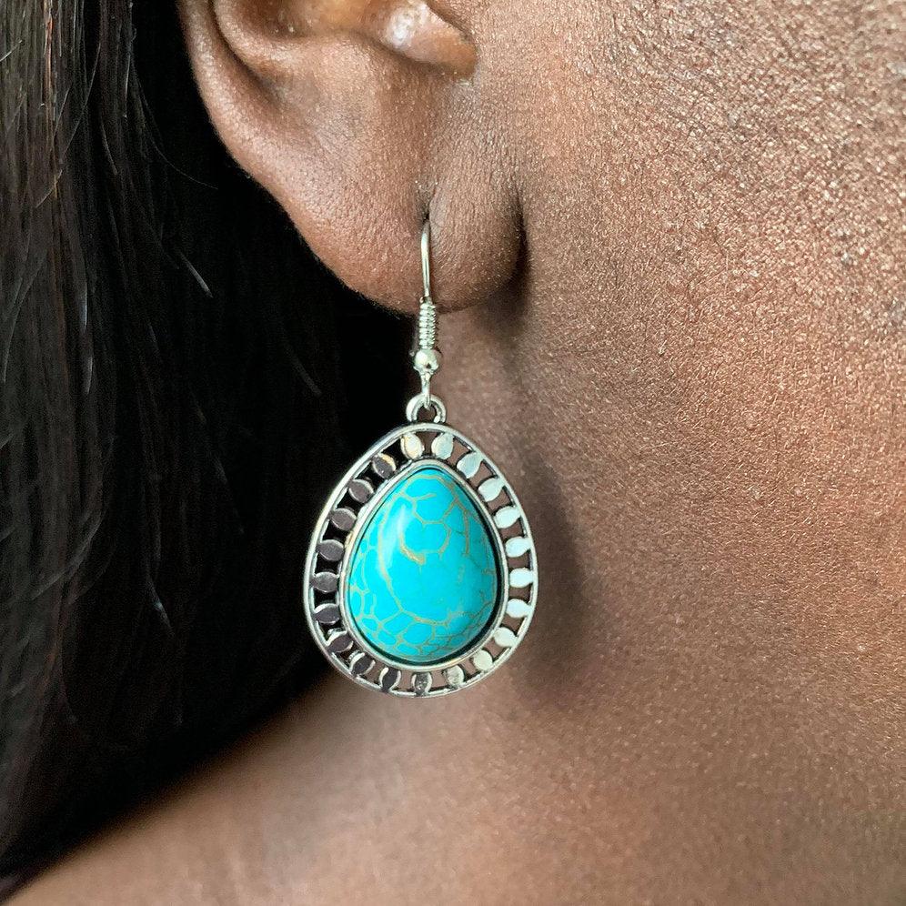 Paparazzi Accessories Sahara Serenity - Blue Chiseled into a tranquil teardrop, a refreshing turquoise stone is pressed into a shimmery silver frame radiating with tribal inspired textures for a seasonal look. Earring attaches to a standard fishhook fitti