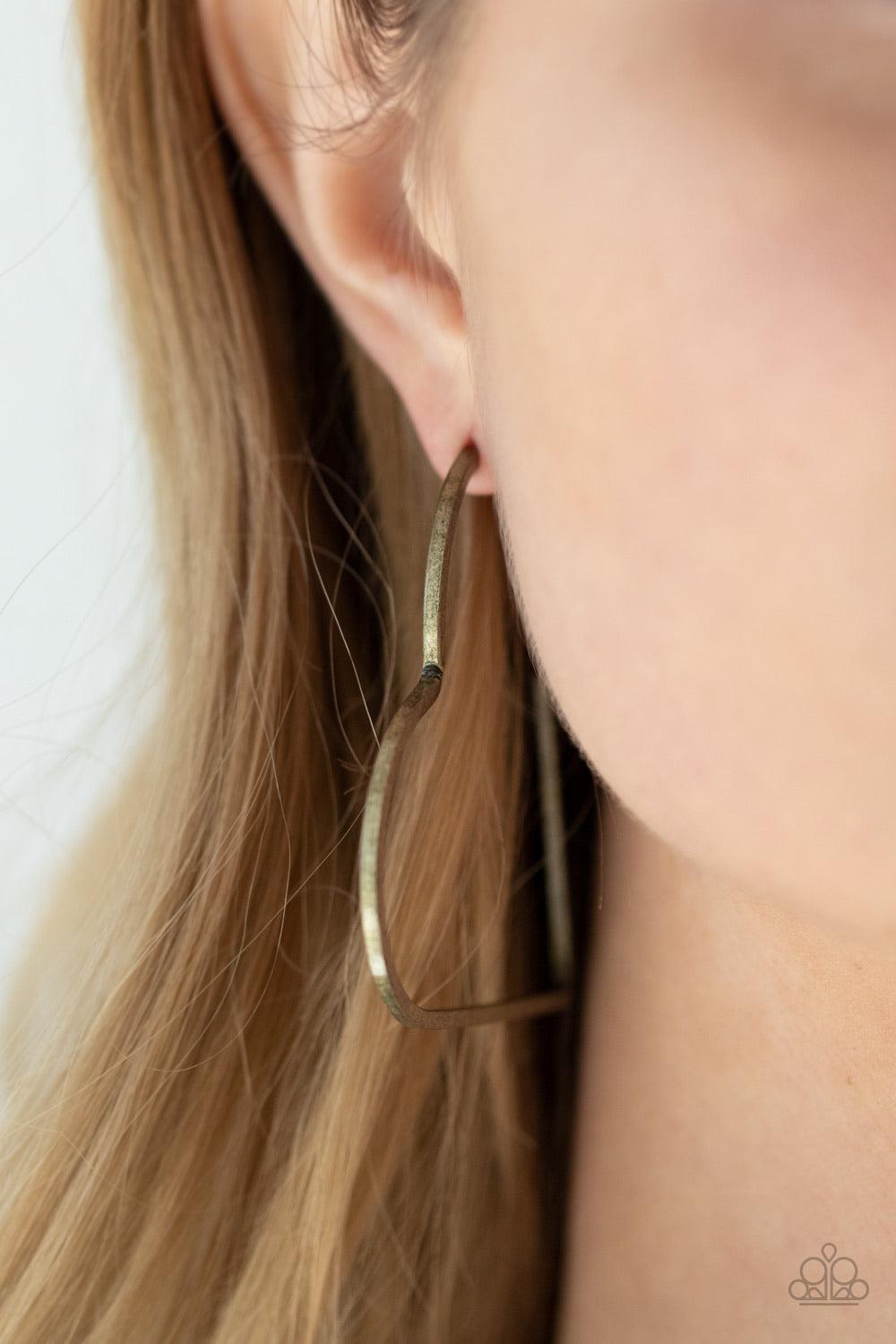 Paparazzi Accessories I HEART A Rumor - Brass Brushed in a rustic antiqued finish, a flat brass bar delicately bends into an airy heart frame for a flirtatious finish. Earring attaches to a standard post fitting. Hoop measures approximately 2" in diameter