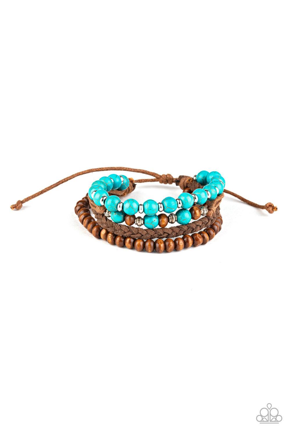 Paparazzi Accessories Renewable Energy - Blue Featuring turquoise stones, dainty silver accents, and earthy wooden beads, mismatched strands of brown cording and braided suede bracelets stack across the wrist for an earthy look. Features an adjustable sli