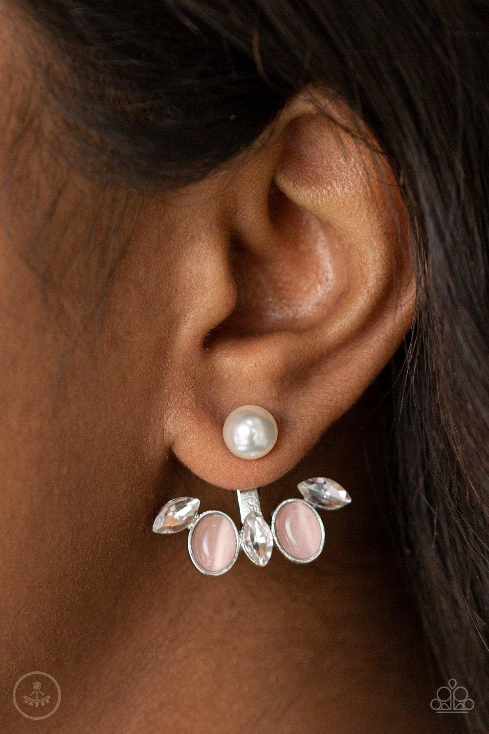 Paparazzi Accessories Modern Sophistication - Pink A solitaire white pearl attaches to a double-sided post, designed to fasten behind the ear. Encrusted in a fringe of glassy white rhinestones and glowing pink cat's eye stones, the angular double-side pos