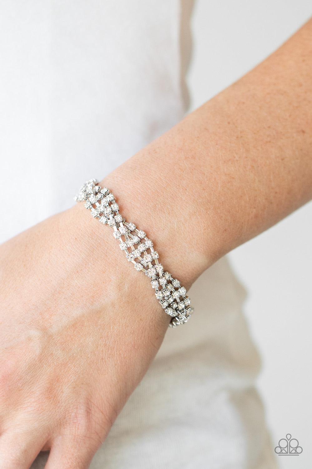 Paparazzi Accessories Twists And Turn - White Featuring glistening silver fittings, strands of glittery white rhinestones delicately braid around the wrist for a glamorously layered look. Features an adjustable clasp closure. Sold as one individual bracel