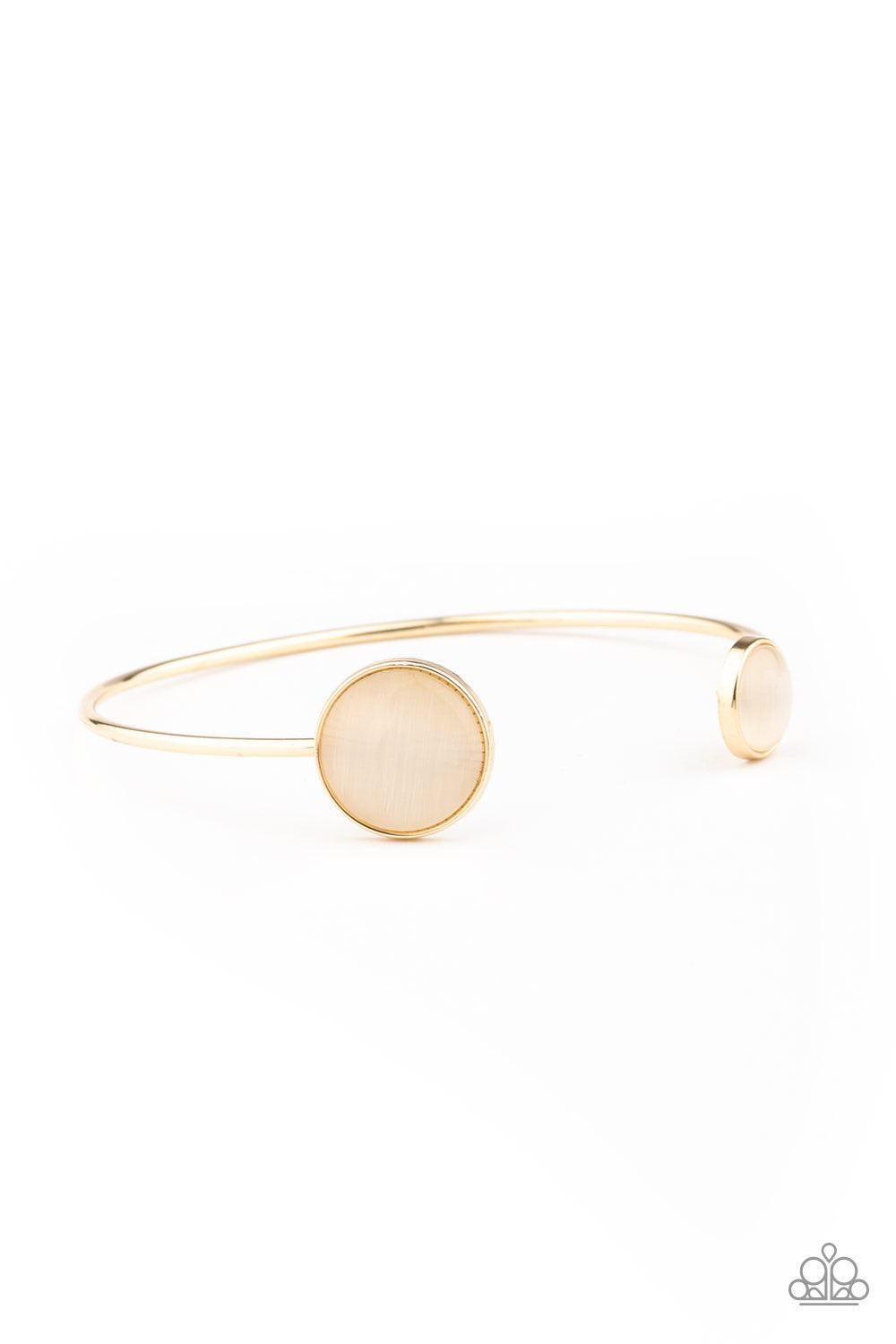 Paparazzi Accessories Brilliantly Basic - Gold Featuring glowing cat's eye stone fittings, a wire-like gold bar curls around the wrist, creating a dainty cuff. Jewelry