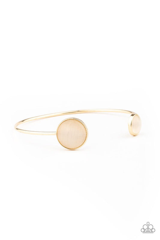 Paparazzi Accessories Brilliantly Basic - Gold Featuring glowing cat's eye stone fittings, a wire-like gold bar curls around the wrist, creating a dainty cuff. Jewelry