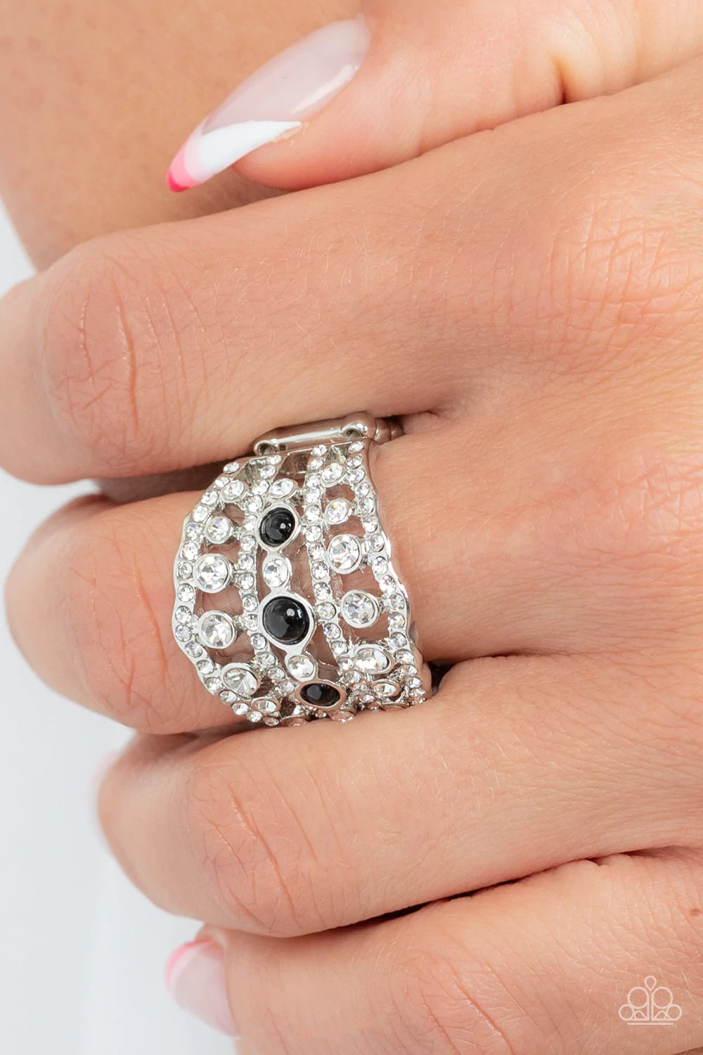 Paparazzi Accessories Sailboat Bling Layers of dainty silver bands, encrusted with sparkling white rhinestones, are accented with a trio of dainty black beads on the centermost band. The stacked layers sweep across the finger, making an exquisite centerpi