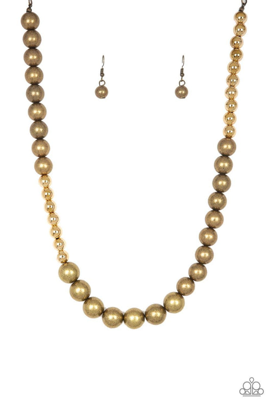 Paparazzi Accessories Power To The People - Brass Varying in size, glistening gold and antiqued brass beads drape below the collar in a dramatically asymmetrical fashion. Features an adjustable clasp closure. Sold as one individual necklace. Includes one