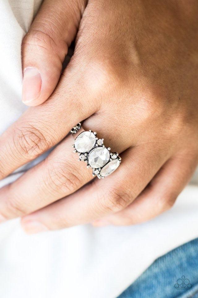 Paparazzi Accessories Straighten Your Crown - White Featuring oval cuts, glittery white rhinestones are encrusted along a regal silver band dotted in dainty white rhinestones. Features a dainty stretchy band for a flexible fit. Jewelry